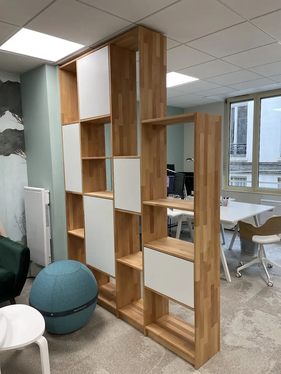 Meuble de séparation en bois et panneaux blancs, installé dans des bureaux