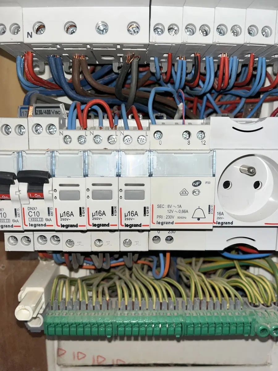 Tableau électrique ouvert avec disjoncteurs, fils et prise